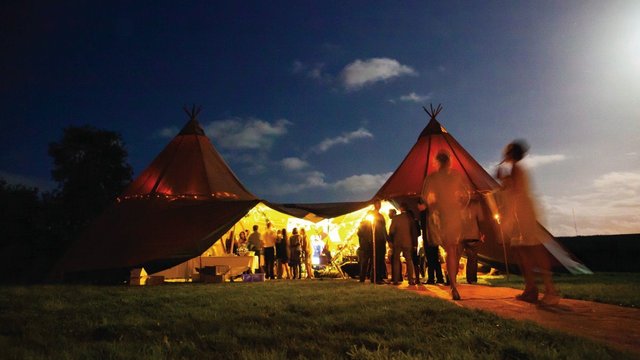 The sun setting over a tipi tent