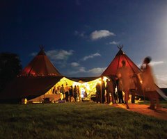 The sun setting over a tipi tent